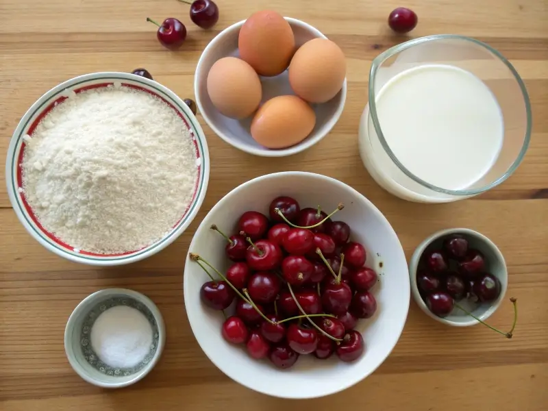 Ingredients for a French cherry dessert arranged on a wooden countertop.