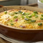 Close-up of a golden cornbread breakfast casserole garnished with green onions.
